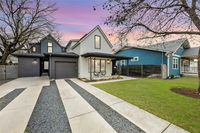 view of front of house with a garage, a yard, fence, and driveway