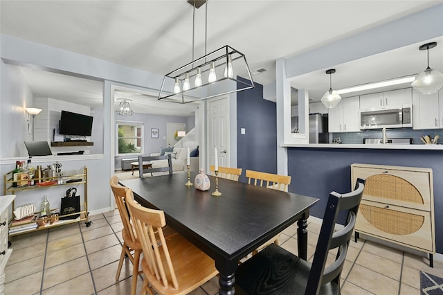 dining room featuring light tile patterned floors, visible vents, and an inviting chandelier