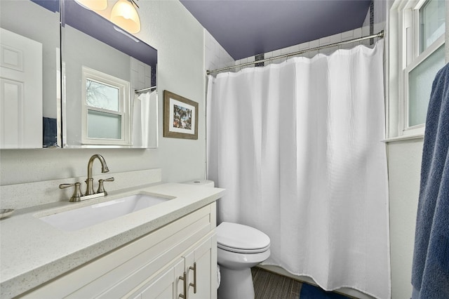 bathroom featuring a shower with shower curtain, toilet, and vanity