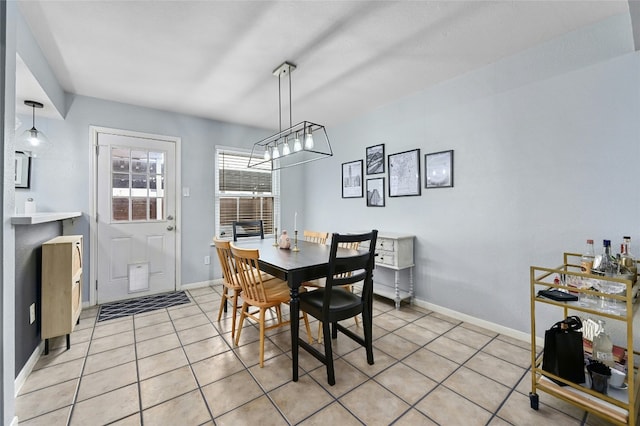 dining area featuring baseboards, a notable chandelier, and light tile patterned flooring