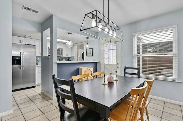 dining space with light tile patterned floors, baseboards, and visible vents