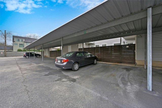 covered parking lot featuring fence