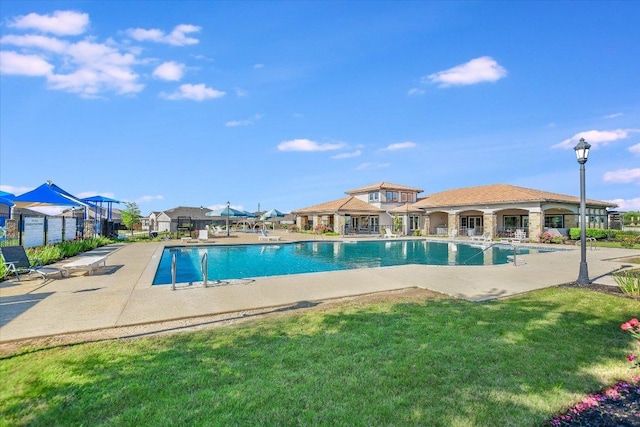 pool featuring a yard and a patio