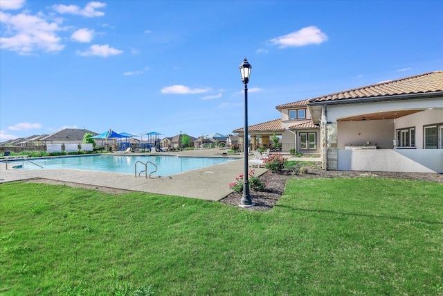 view of swimming pool with a yard, a patio, fence, and a fenced in pool