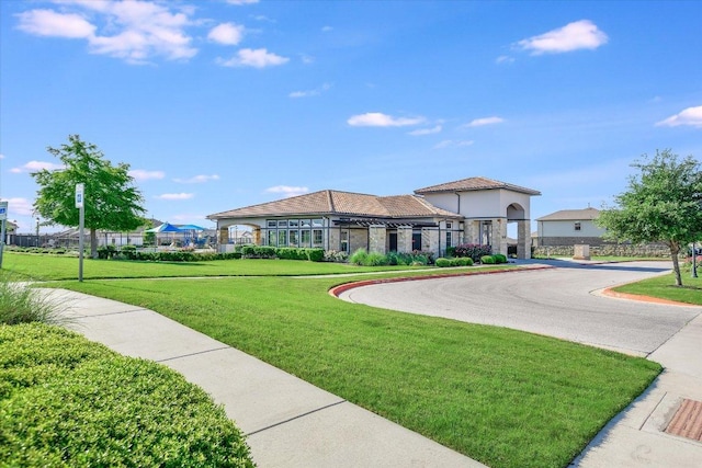 exterior space with aphalt driveway and a lawn