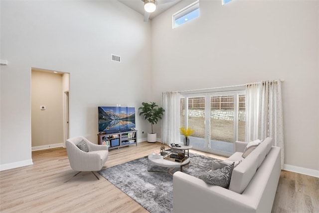 living room with french doors, visible vents, a high ceiling, wood finished floors, and baseboards