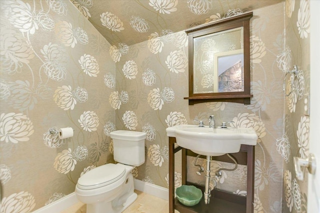 bathroom with baseboards, a sink, and toilet