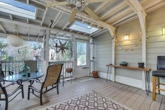 sunroom featuring lofted ceiling with skylight