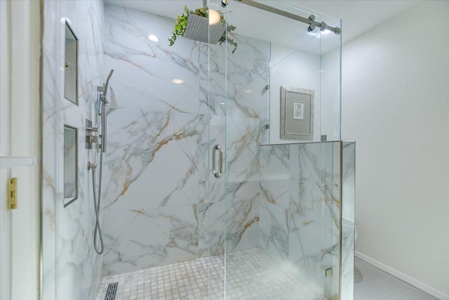 bathroom with a marble finish shower and baseboards