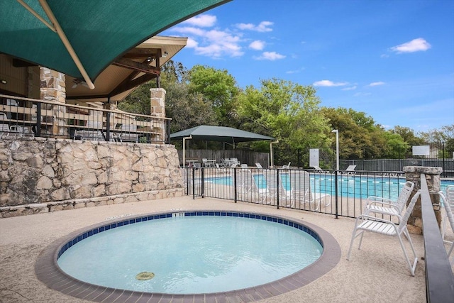 community pool with a community hot tub, a patio area, and fence