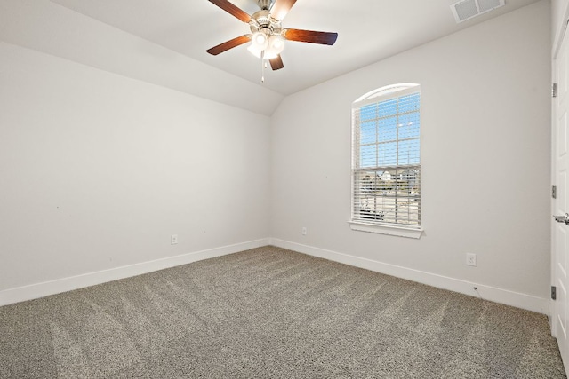 carpeted spare room with vaulted ceiling, ceiling fan, visible vents, and baseboards