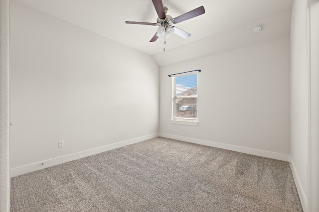 carpeted spare room featuring lofted ceiling, a ceiling fan, and baseboards