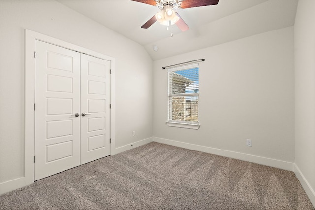 unfurnished bedroom featuring carpet floors, a closet, vaulted ceiling, ceiling fan, and baseboards