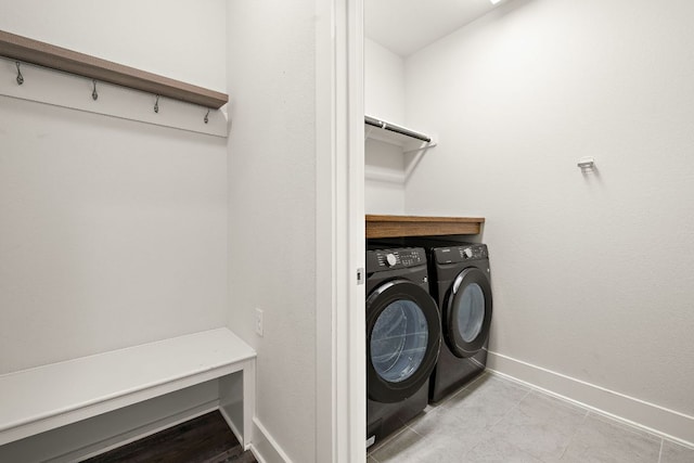 washroom with laundry area, baseboards, and washer and clothes dryer