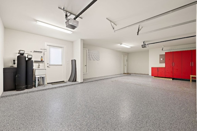 garage with a sink, electric panel, and a garage door opener