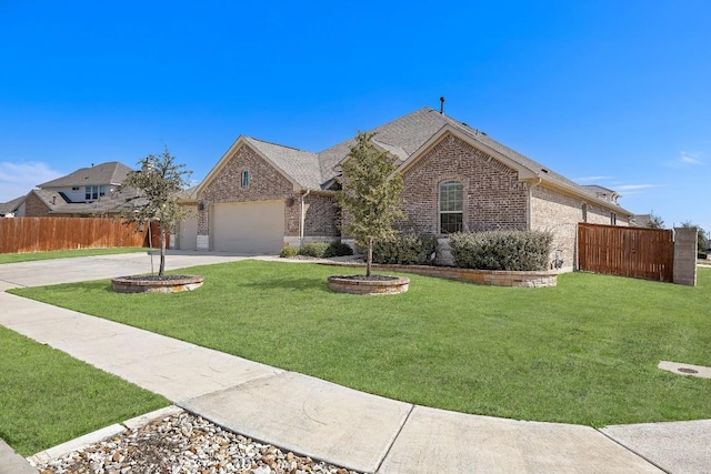 view of front of property featuring an attached garage, brick siding, fence, driveway, and a front lawn