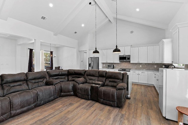 living area featuring beam ceiling, visible vents, dark wood finished floors, and high vaulted ceiling