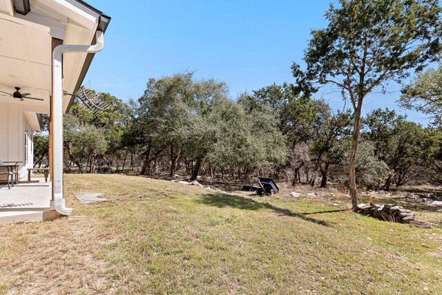 101 Saddle Mtn, Boerne, TX 78006 - view of green lawn with a ceiling fan and view of wooded area