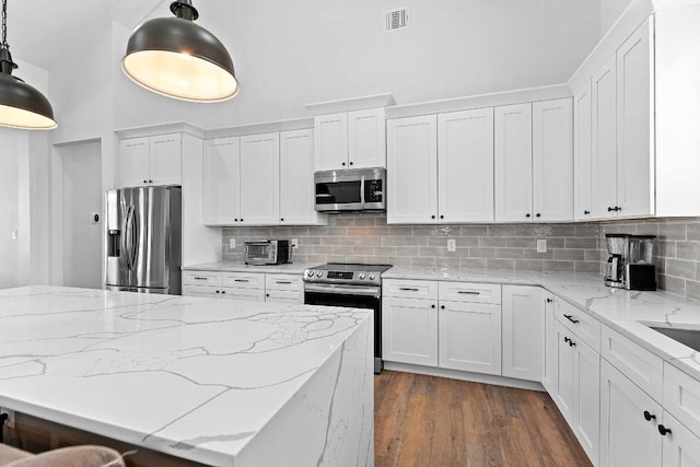 101 Saddle Mtn, Boerne, TX 78006 - kitchen with appliances with stainless steel finishes, white cabinets, dark wood-style floors, pendant lighting, and a towering ceiling