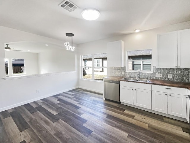 127 Campos Dr, Hutto, TX 78634 - kitchen with stainless steel dishwasher, butcher block counters, decorative backsplash, and white cabinets