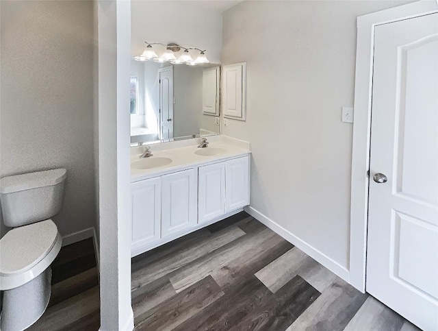 bathroom with baseboards, a sink, and wood finished floors