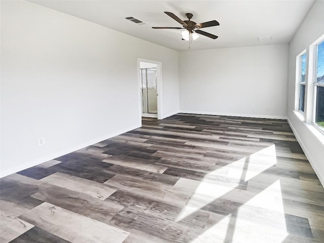 empty room with visible vents, ceiling fan, baseboards, and wood finished floors