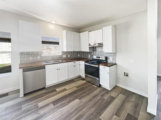 kitchen with stainless steel appliances, butcher block counters, backsplash, a sink, and under cabinet range hood