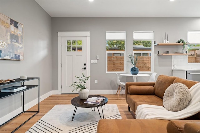 living room with light wood-style floors, plenty of natural light, and baseboards