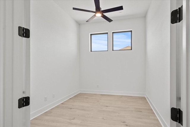 spare room with baseboards, ceiling fan, and light wood-style floors