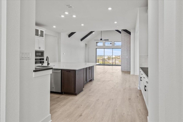 kitchen with decorative backsplash, appliances with stainless steel finishes, light wood-style floors, a sink, and dark brown cabinets