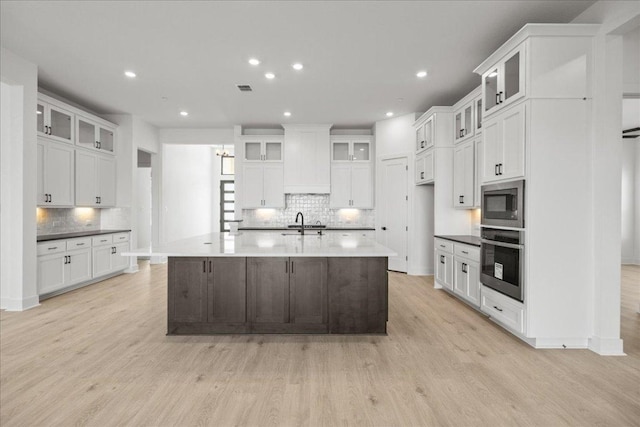 kitchen featuring light wood-style floors, a spacious island, white cabinetry, and stainless steel appliances