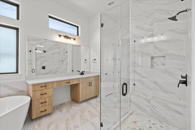 bathroom with a towering ceiling, vanity, marble finish floor, a soaking tub, and a marble finish shower