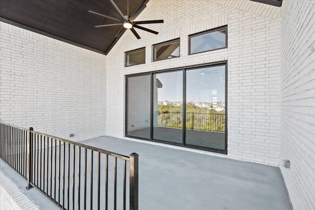 view of exterior entry featuring ceiling fan and brick siding