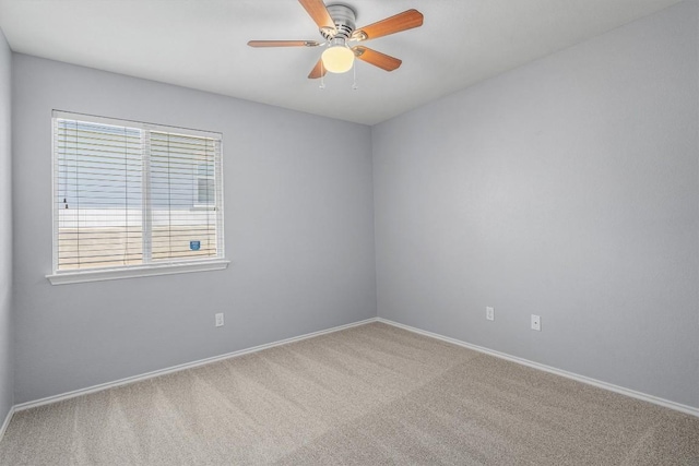 carpeted empty room featuring baseboards and a ceiling fan