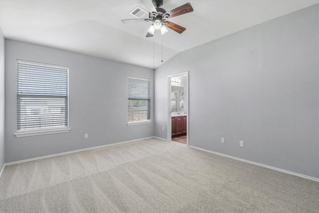 unfurnished room with light carpet, baseboards, visible vents, a ceiling fan, and vaulted ceiling