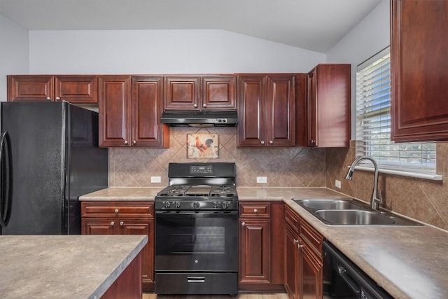 kitchen with tasteful backsplash, under cabinet range hood, vaulted ceiling, black appliances, and a sink