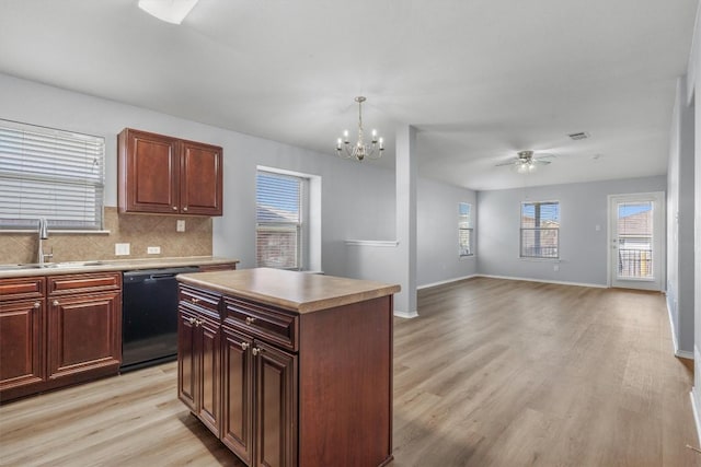 kitchen featuring black dishwasher, light wood finished floors, decorative backsplash, a sink, and ceiling fan with notable chandelier