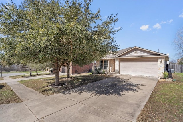 view of front of property featuring an attached garage, stone siding, fence, and concrete driveway