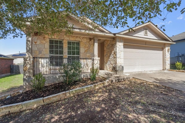 single story home featuring concrete driveway, a porch, an attached garage, and stone siding