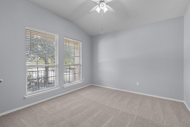 carpeted spare room featuring ceiling fan, baseboards, and vaulted ceiling