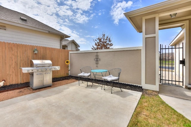 view of patio / terrace featuring a gate, a grill, and fence