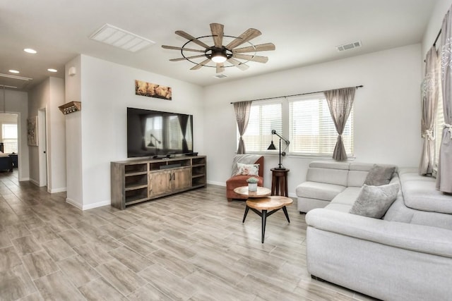 living area with attic access, a wealth of natural light, visible vents, and ceiling fan