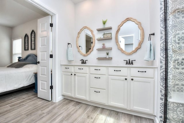 bathroom featuring wood tiled floor, a sink, ensuite bath, and double vanity