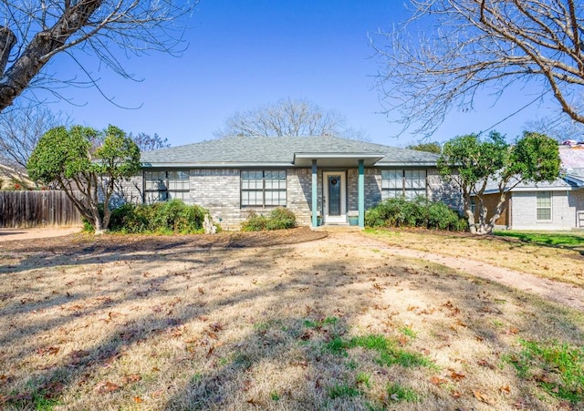 ranch-style home featuring fence and brick siding