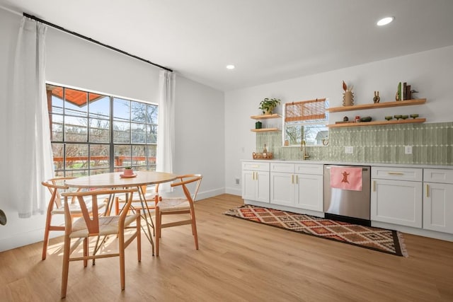 kitchen featuring light wood-type flooring, a healthy amount of sunlight, dishwasher, and open shelves