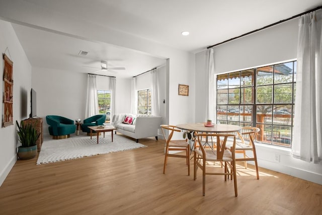 dining room with baseboards, wood finished floors, visible vents, and a ceiling fan