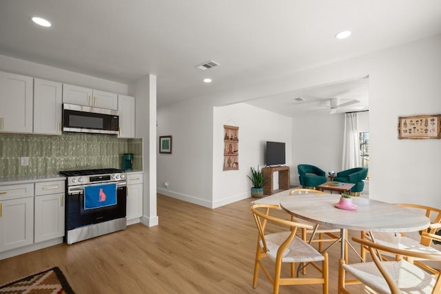 kitchen with tasteful backsplash, visible vents, baseboards, appliances with stainless steel finishes, and light wood-type flooring