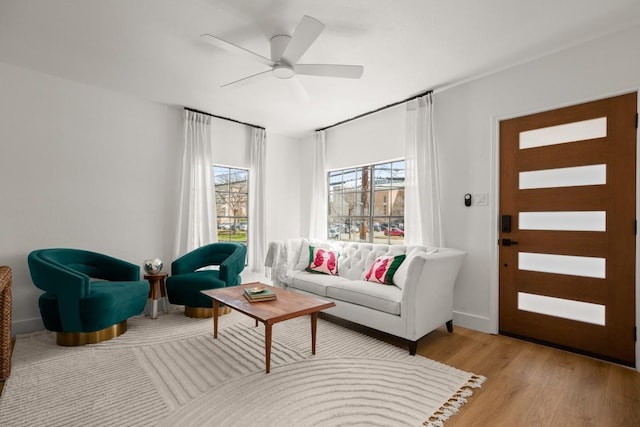 living area with light wood-style flooring and ceiling fan