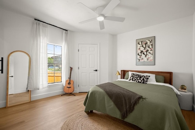 bedroom featuring light wood-style flooring, baseboards, and ceiling fan