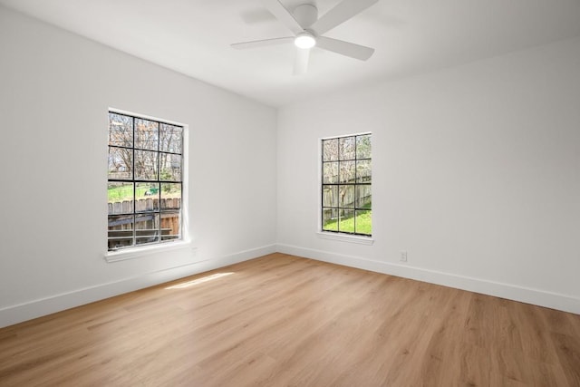 unfurnished room featuring ceiling fan, light wood-style flooring, and baseboards